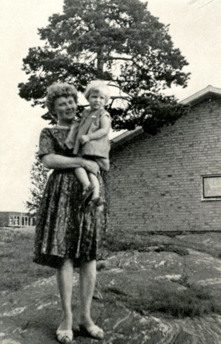 Gunvor Eriksson Klingvall (1923 - 1970) håller en liten flicka i famnen, Sporred cirka 1965.