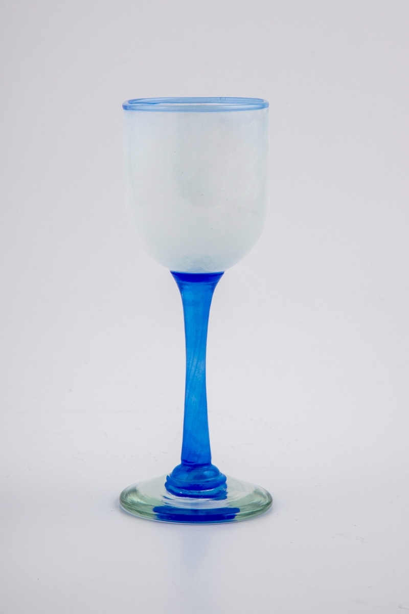 Vinglass med hvit halvgjennomskinnelig kupa. Munningen er markert med blålig glass. Stetten er utført i klart blåfarget glass, og hviler på en sirkulær fot.