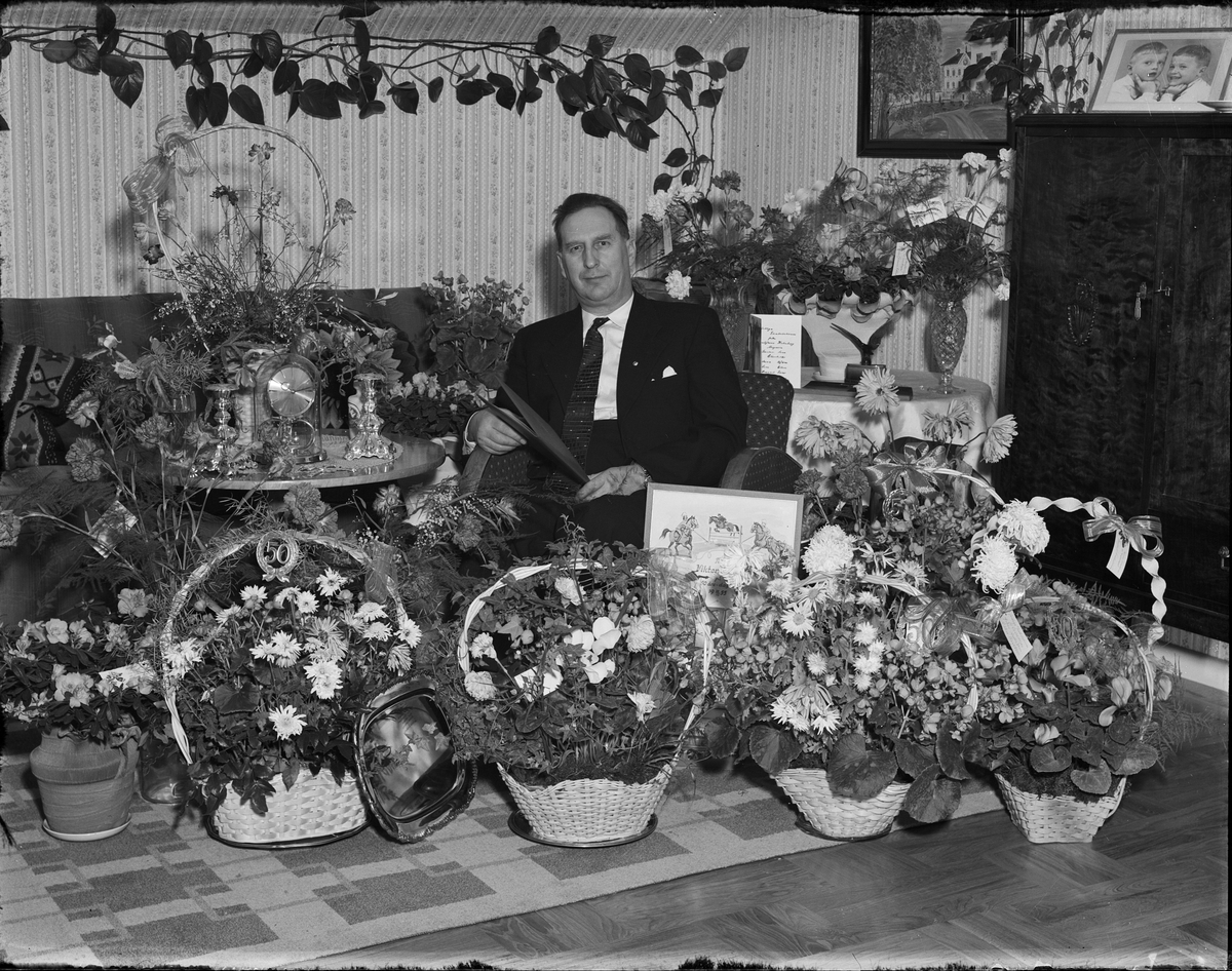 Man i hemmiljö omgiven av blommor firar 50-årsdagen, Östhammar, Uppland