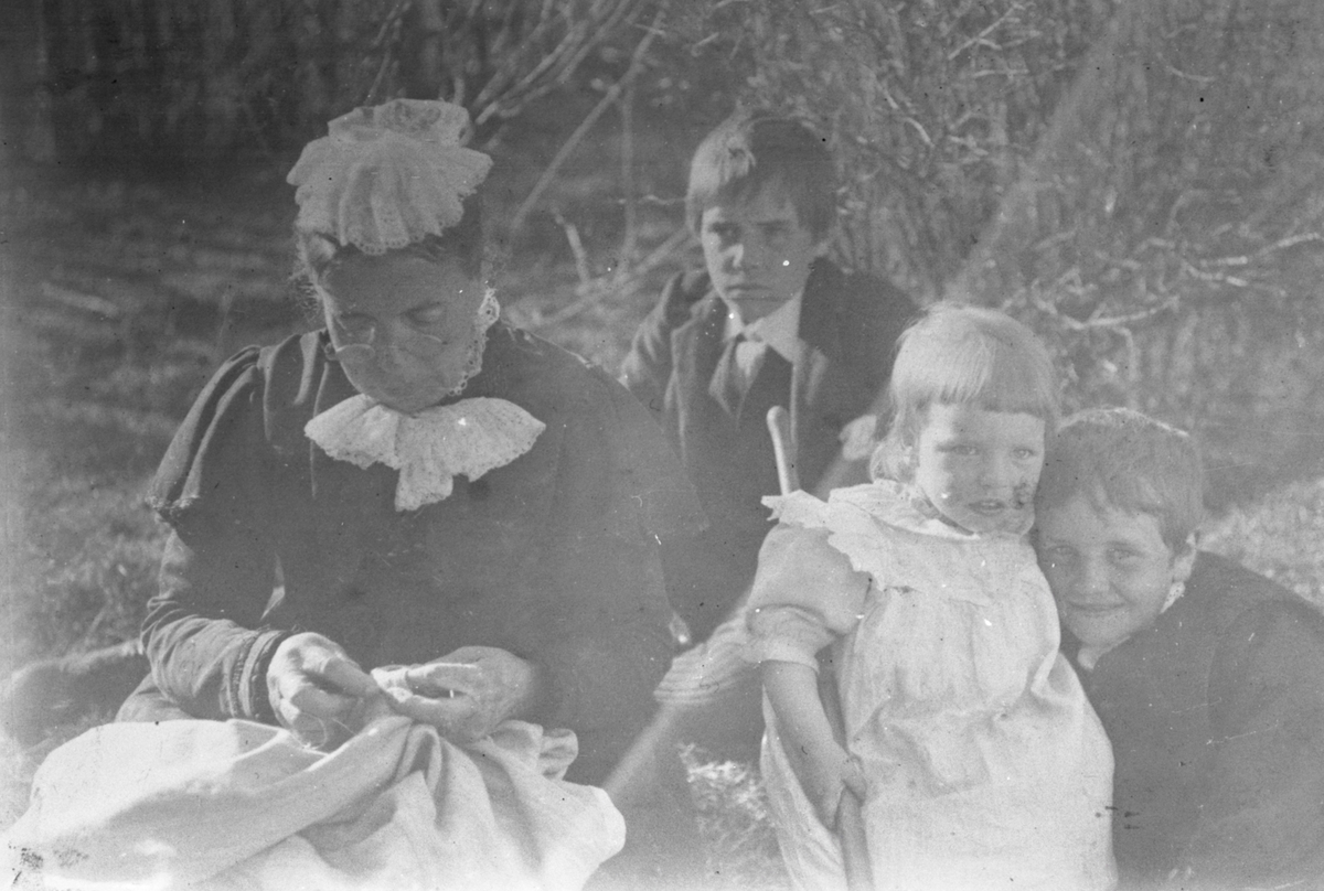 Gruppeportrett av tre barn og ei kvinne fra familien Aston.