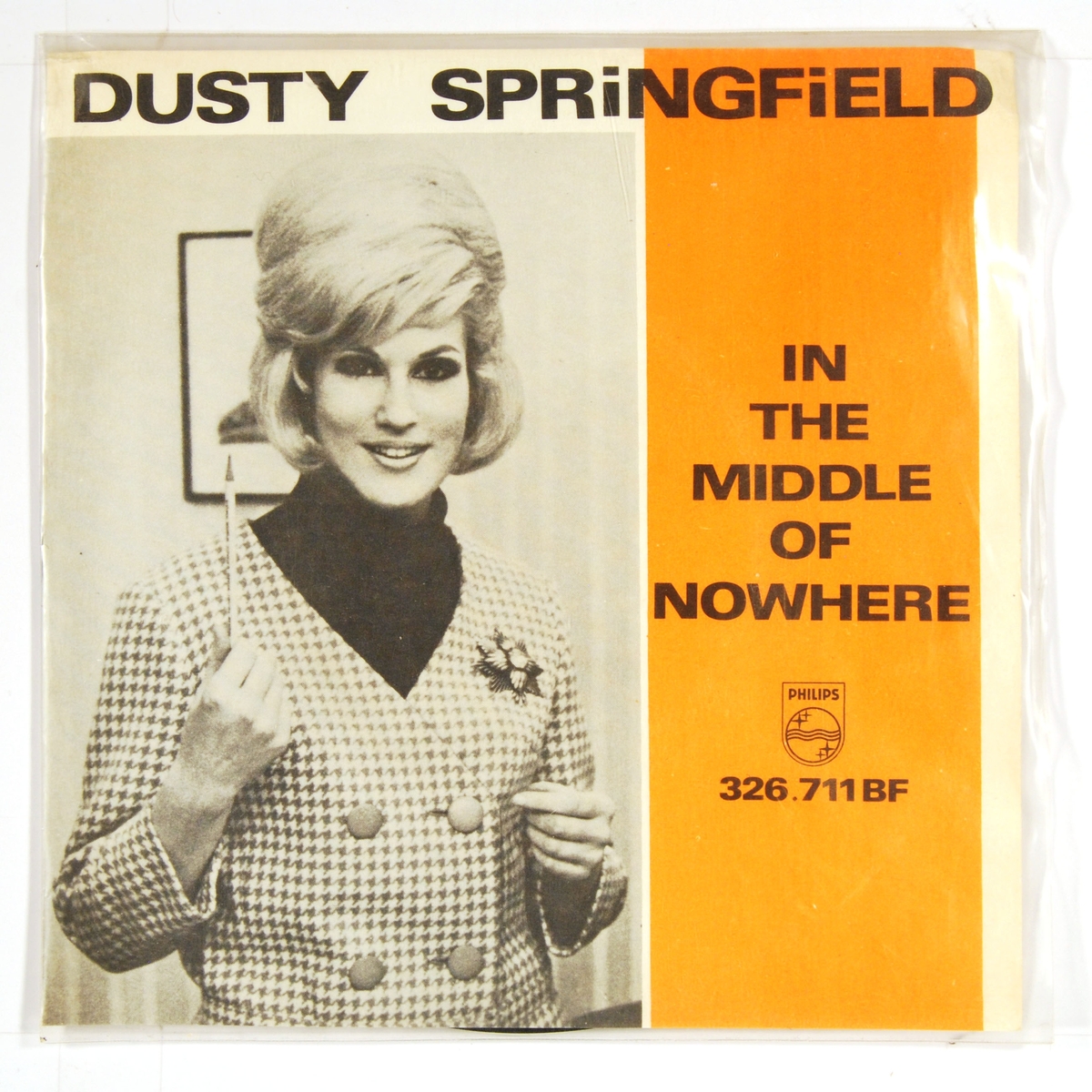 Bilde av Dusty Springfield som holder en blyant i høyre hånd, pekende oppover.