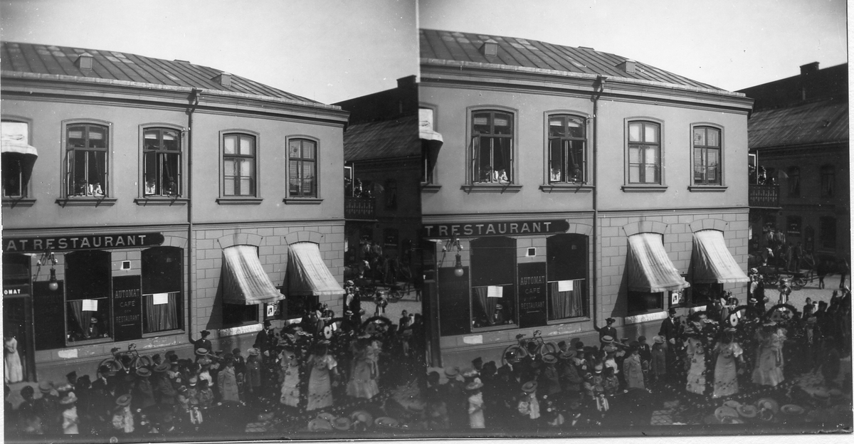 Halmstad, Storgatan. Kv Brovakten, kv Klingberget. Närmast Wallbergs hörna. Numera rivet för uppförande av Göteborgs bank 1925. Paraden på gatan kan möjligen vara från Barnens dag 1907.