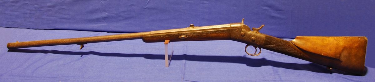 Enkelpipigt hagelgevär av system Remington. Huskvarna modell 12. kaliber: 20, slätborrad pipa. Tillverkningsnummer: 30364 från 1896. Tidig form av stopphane. pipans mynning är skadad