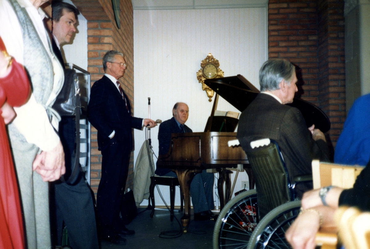 Musikunderhållning i Brattåsgårdens matsal (Streteredsvägen 5) år 1989. Vid mikrofonen står Malmfelt och vid flygeln sitter Rutger Milsta (från Lindome). Övriga är okända.