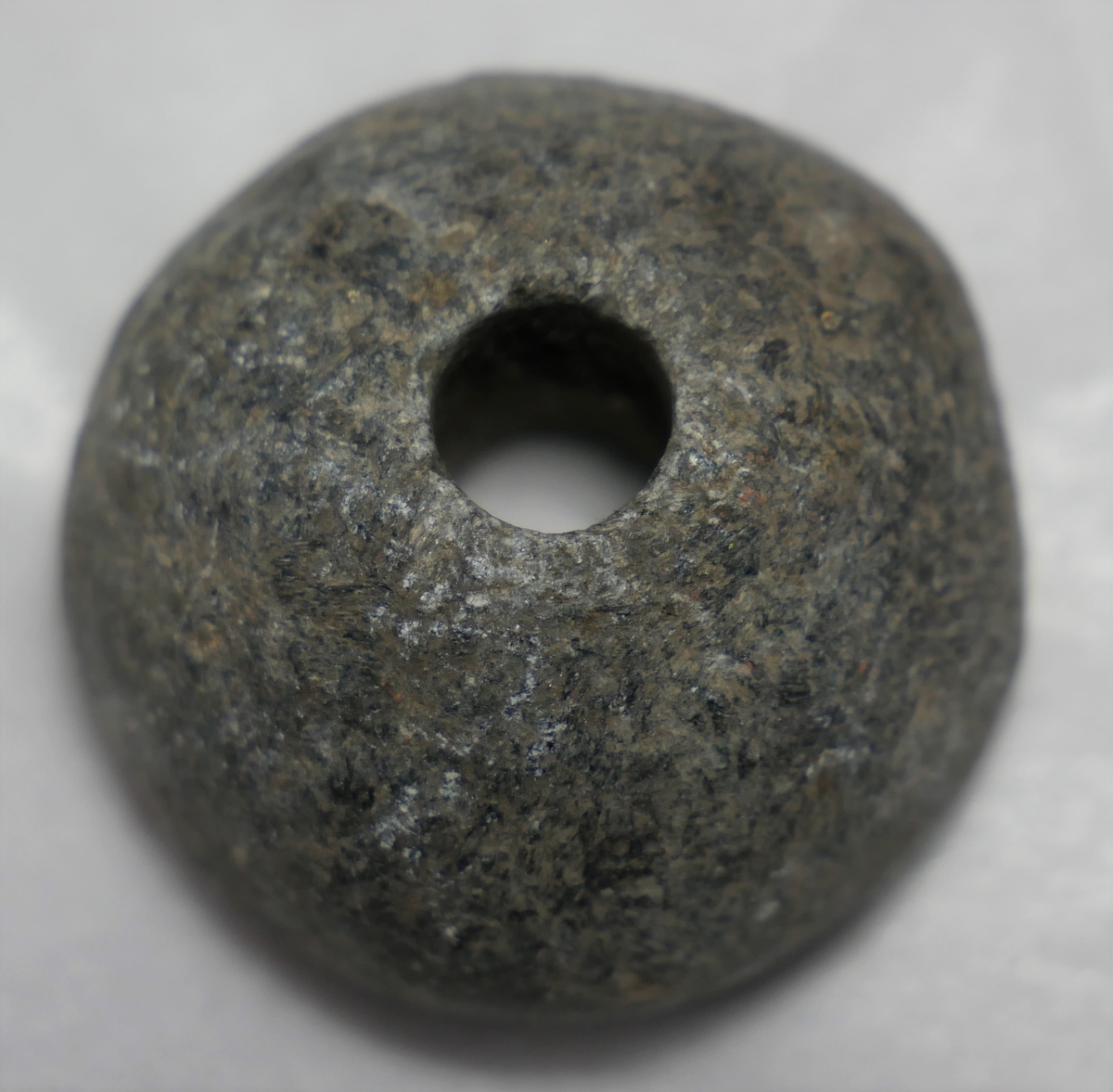 
1 haandsneldehjul.

Haandsneldehjul, halvkugleformet, av en klæberartet stensort. Diameter 3,1 cm, høide 2,1 cm. Fundet ved nylandsgraving i Tømmerlidsbakken, Amble.
Gave fra husmand Torbjørn Eneteig, Amble.