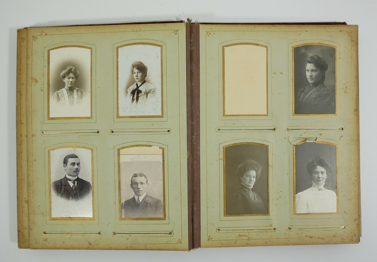 Rektangulært stående fotoalbum med 30 sider. Albumet har omslag med falmet rødt tekstil med dekor midt på på forsiden. På den ene siden på forsiden er det en metalldel. 