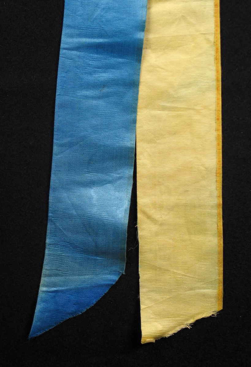 Begravelsessløyfe i gul og blå silke uten tekst.