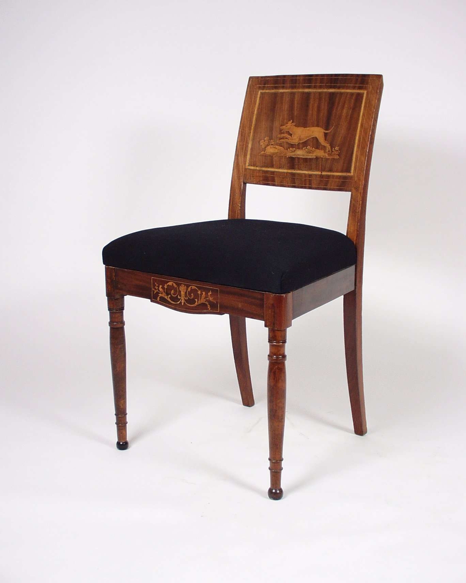 Stolene er av mahogny med løst sete trukket med svart tekstil. Trekket er betydlig nyere enn selve stolen. Stolenes forbein er dreid og ryggbrettet har motiver i intarsia av lyst tre. Også sarg har dekor i intarsia av lyst tre. Ryggbrettets dekor er dyremotiv. Stolen er i empire-stil.