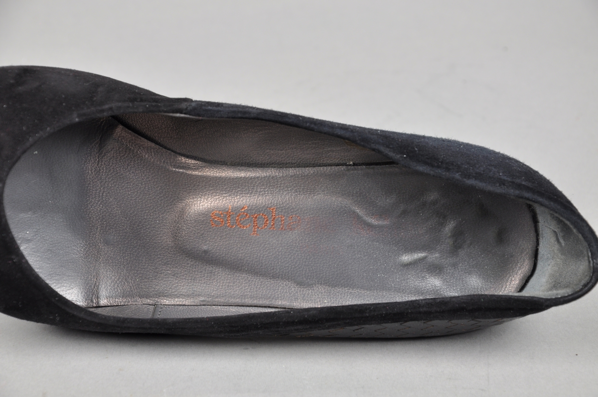 Sorte sko av semsket skinn med flettet skinnbesetning. Skoene har høy hæl. Merket er stéphanie kélian.