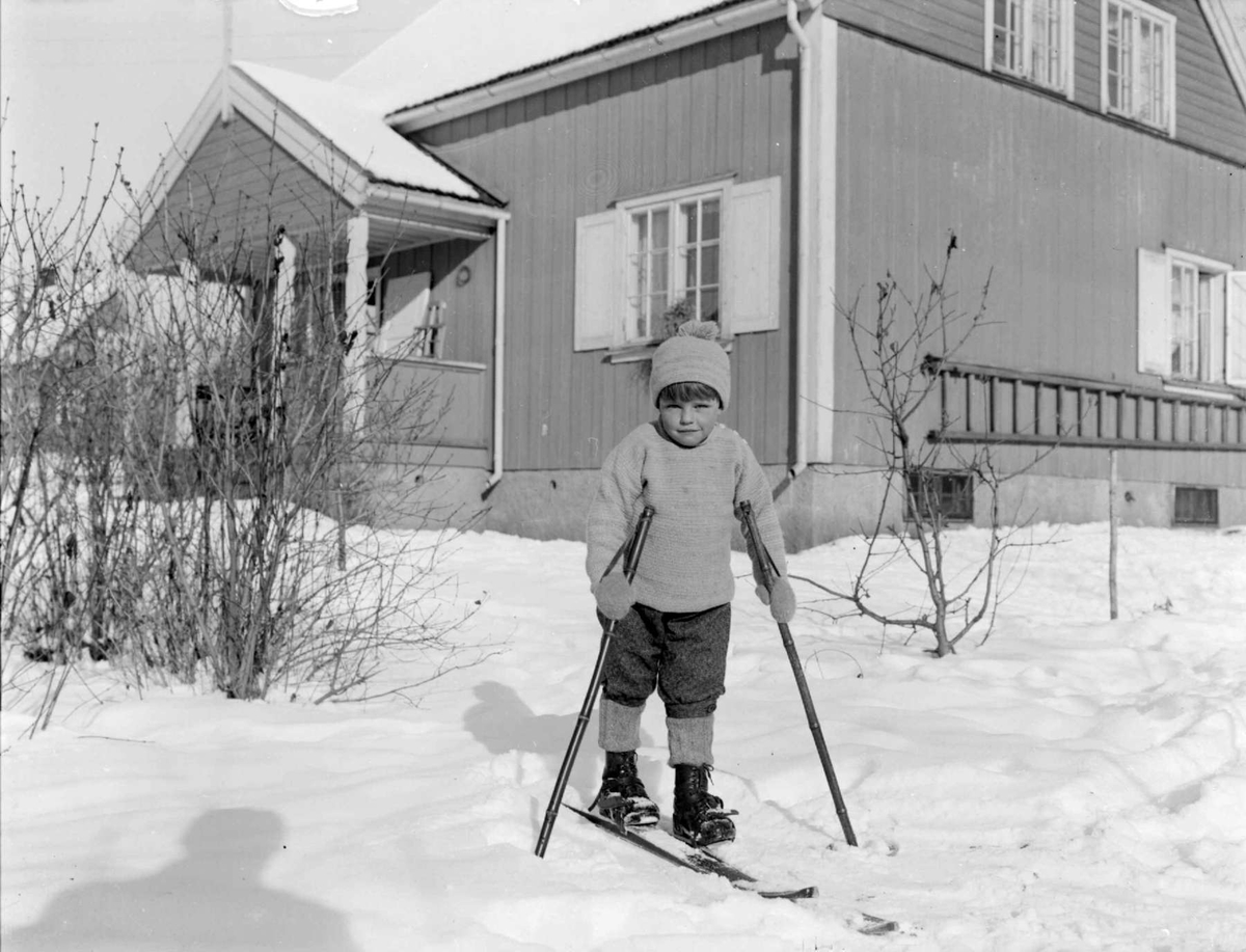 Liten gutt på ski utenfor hus. Vinteren 1929. Gunnar Berge.