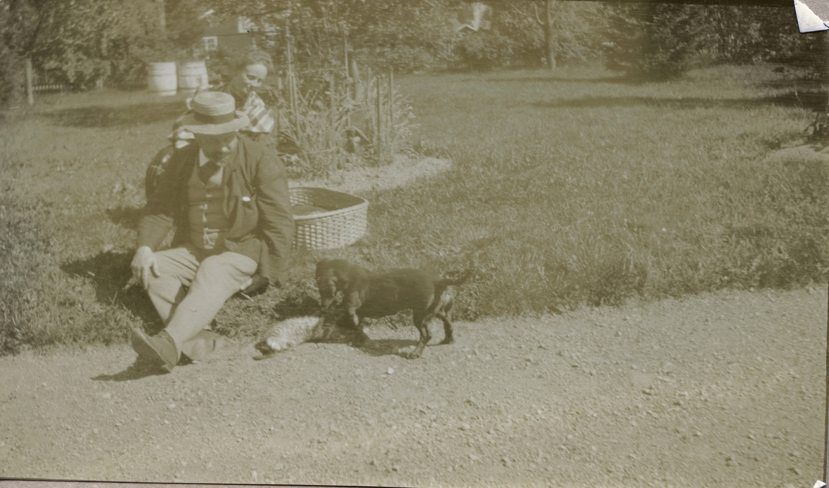 Gabriel Kielland Hauge og en dame i hagen med en katt og en hund.