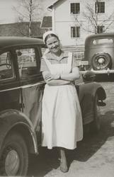 Frk.Hustad i arbeidsuniform ved hovedbygningen på Frogner gå