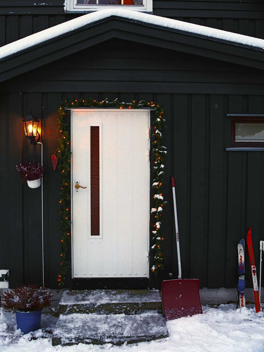 Julebelysning

Hvit julebelysning i girlander ved dørparti ved enebolig