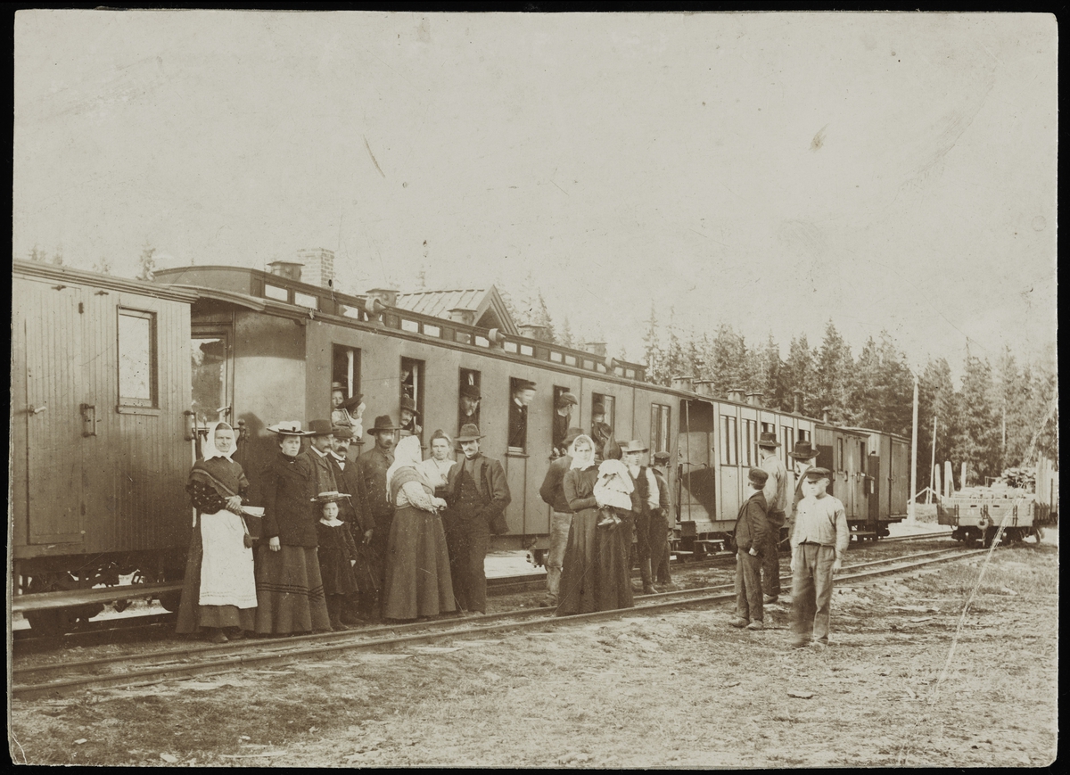Reisende og pyntet lokalbefolkning ved togankomst på Hjellebøl stasjon, muligens i forbindelse med mobilisering av styrker til Urskog fort 18. september 1905.