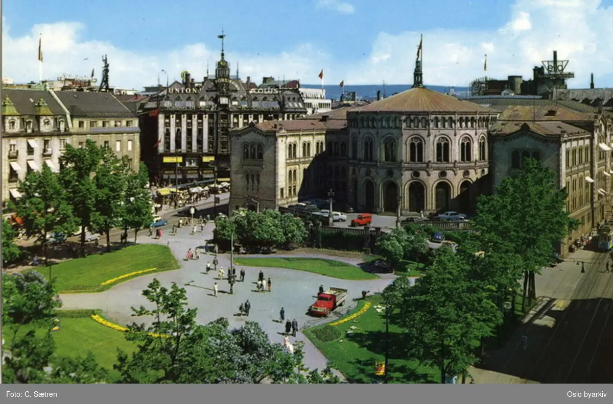 Stortinget og Eidsvolls plass. Stortingsgata med trikk. Stortings plass med uteservering ved Tostrupgården (takreklame for Union forsikring). Grand Hotel helt til venstre. Sannsynligvis fra 1960-tallet. Postkort F-1661-4.