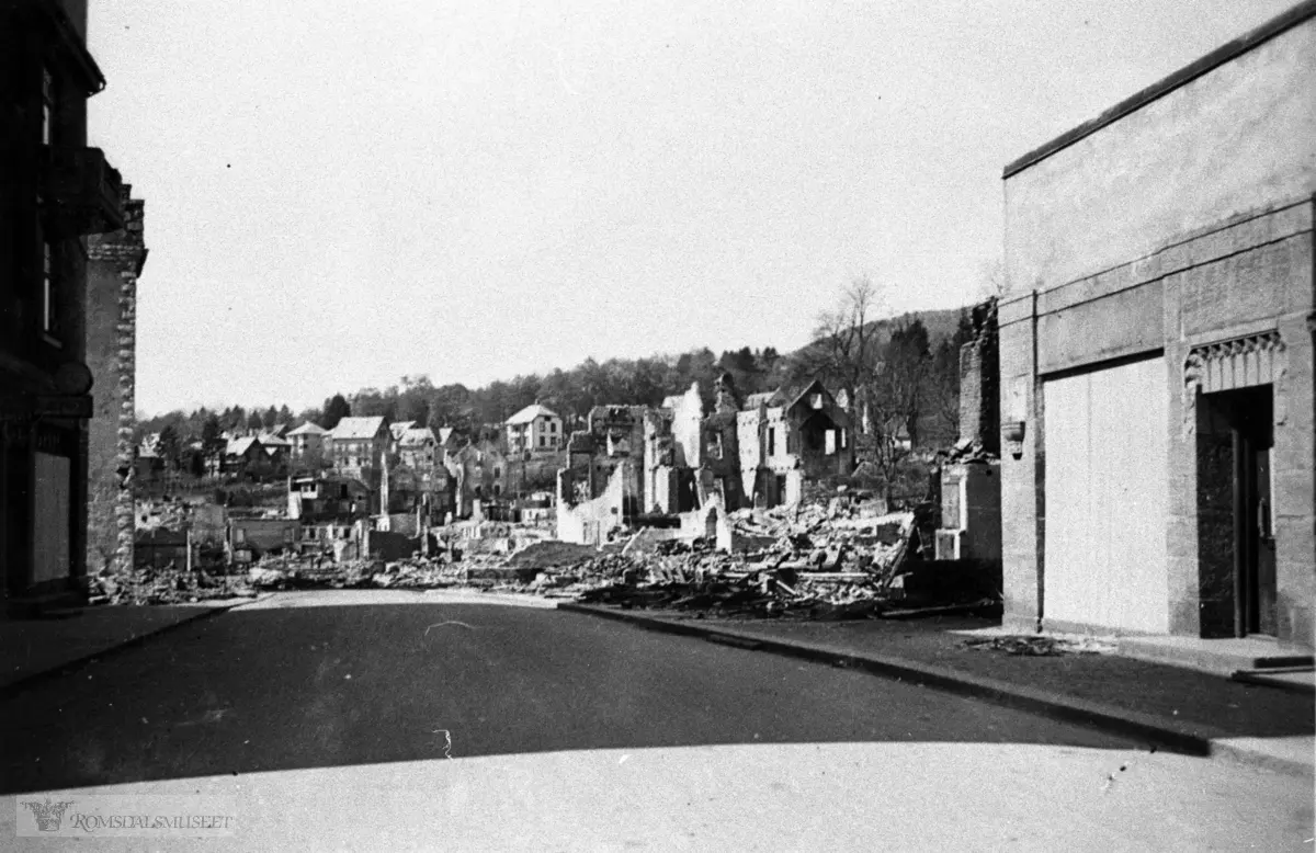 Molde sentrum vestover, april 1940. Til venstre på bildet sees et hjørne av Elvsåsgården..Til høyre ser vi butikken til Beck..(Tidligere trelastgården). Ved sida av denne er ruinene av Festiviteten.