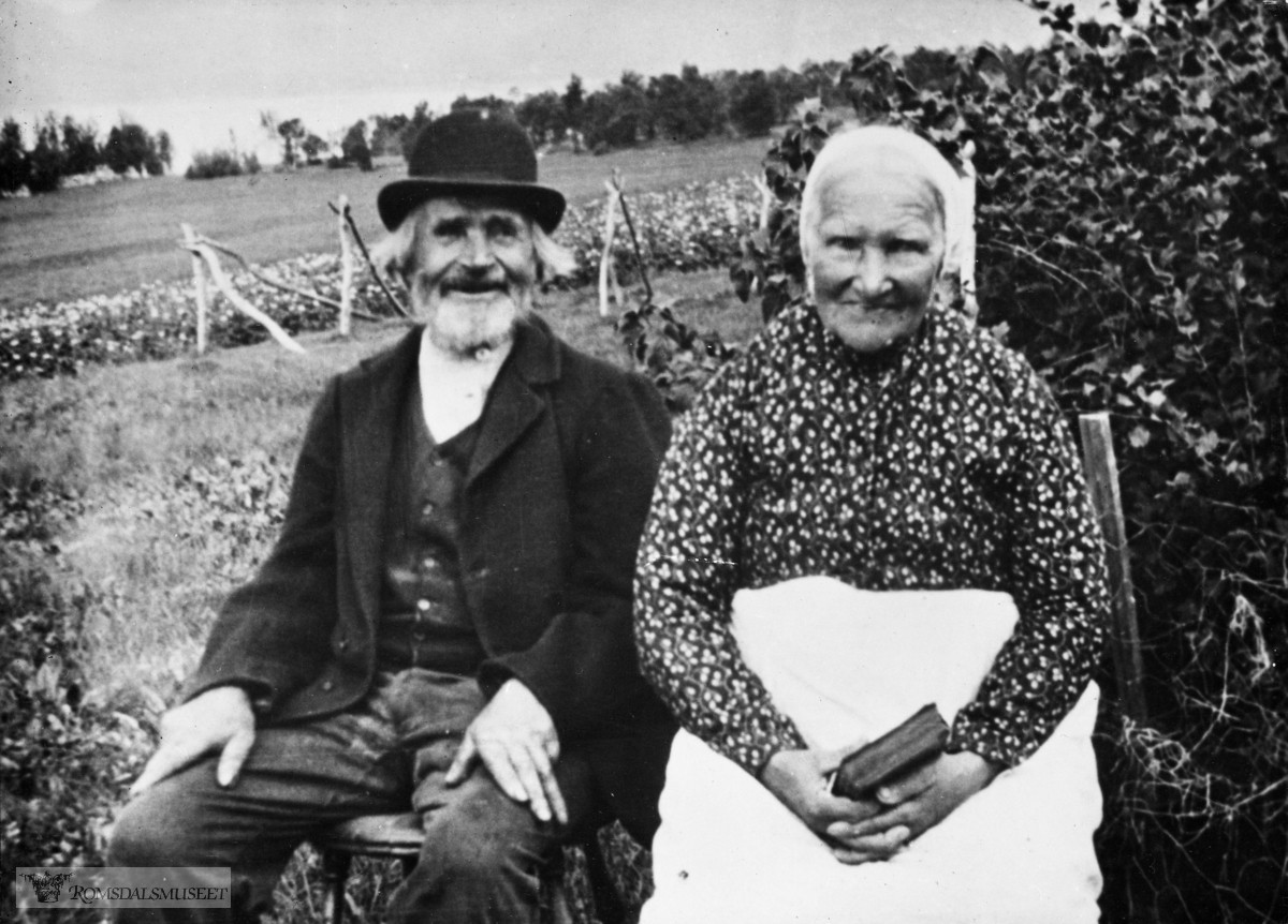 John Sivertsson Rekdal (Jo i Myrå) og hans kone Caroline Elisabeth Pedersdatter Indre-Skodje..Hun kom fra Skodje, mens han var født på Rekdal. .Bildet er tatt i hagen på gården "Myrå" på Rekdal. .De var foreldre til Karen Serine f.1873 (ligger begravd ved Borgund Kirke), Peter Rekdal (Elin Rekdal Skogstad sin oldefar) f. 1875, Josefine f. 1877, Ane Marie f. 1880 og Sivert Rekdal f. 1882, som drev Rekdal Margarinfabrikk i Ålesund. Peder f. 1887 døde av tuberkulose i 1908.