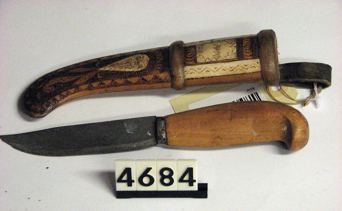 Kniven er laget av russiske krigsfanger og gitt til Ingeborg og Nils M Rygh i Ålesund. Skjeftet er laget av tre og bein, det samme er sliren. Den har flotte utskjæringer