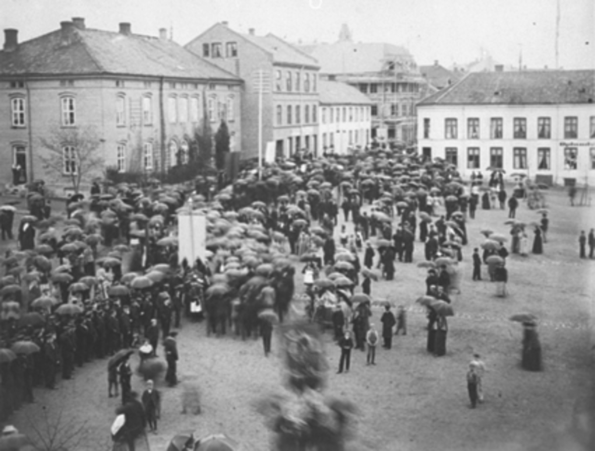 Fellestoget 17.mai 1899 på Stortorget. Torggata 83 i forgrunnen, Oplandske Hotell i bakgrunnen.