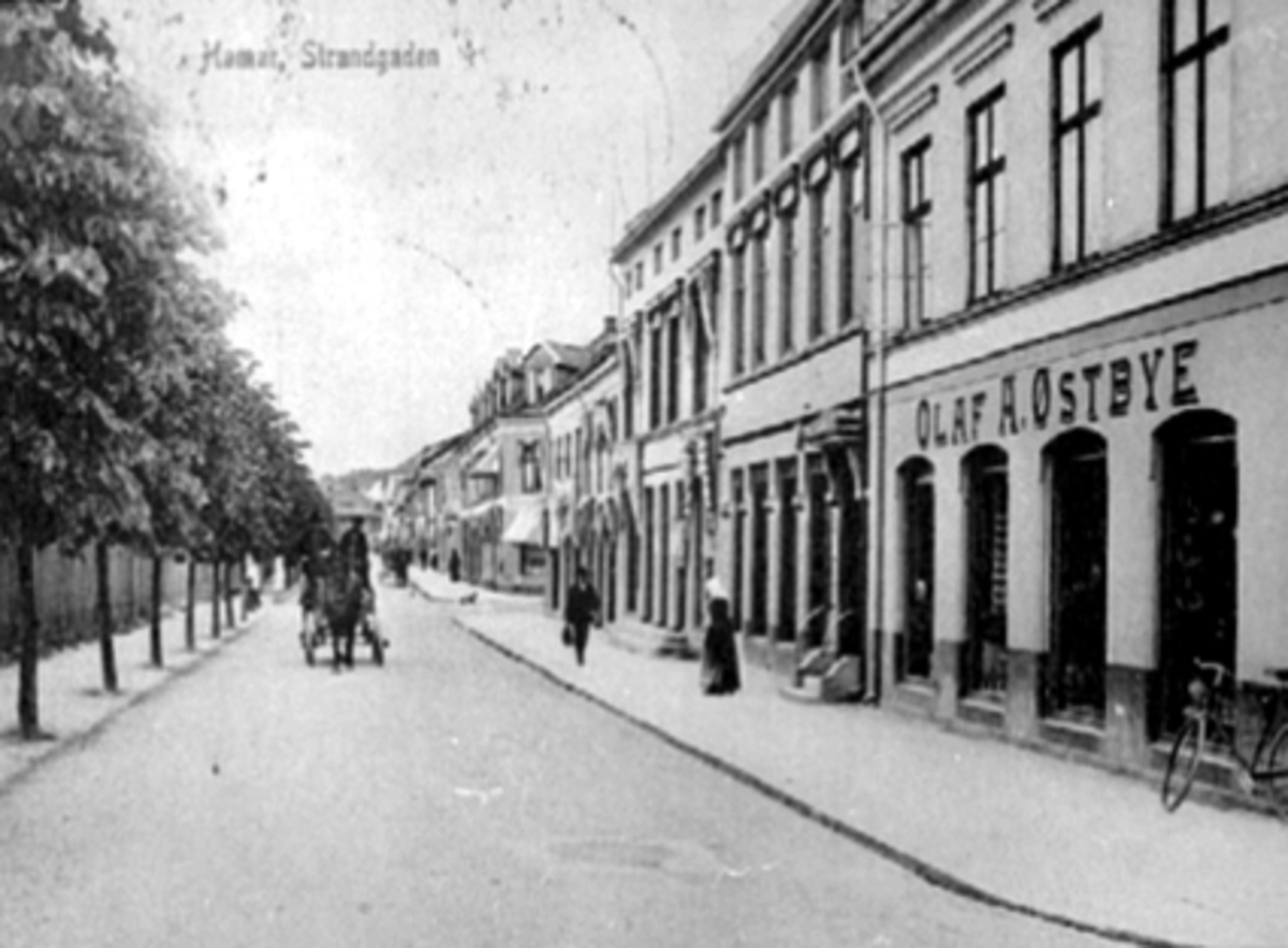 Postkort, Hamar, Strandgata 13, Olaf A. Østbye sin forretning, bygård, hest og kjerre,