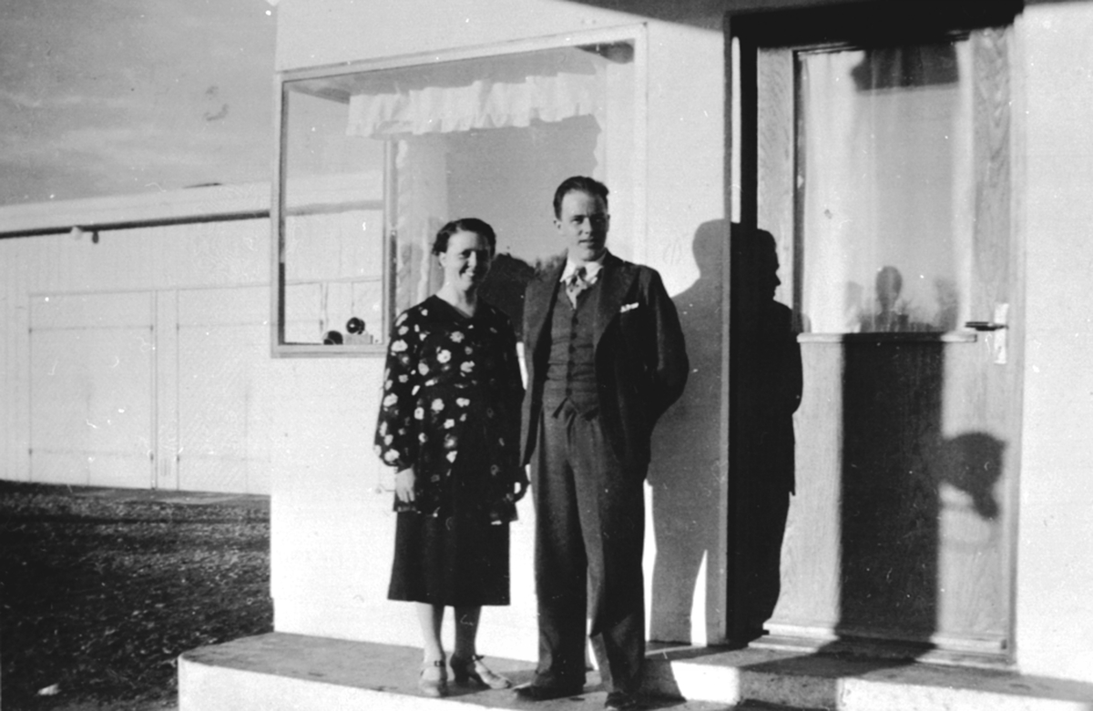 Johannes Haug (1909-1986) med kone Paula Sofie Sveum (1911-1994) foran bensinstasjonen, Nes Bilverksted, Nes, Hedmark.
