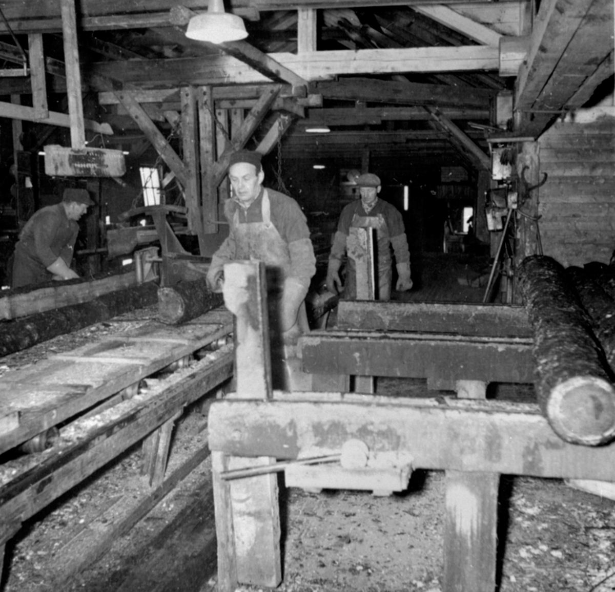 3 arbeidere ved tømmerskjæringen, sagbruk, fra venstre Hans Roterud, Nils Simensen, Ottar Tangen, Berger Langmoen A/S, Brumunddal.