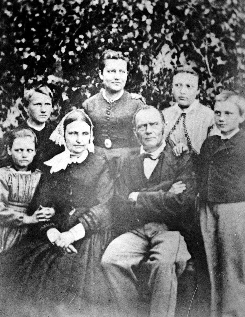 Familien på Hovelsrud, Helgøya. Foran fra venstre er Louise (1859-1935), Karoline Olsdatter (1818-1884), Nils Jacobsen Hoel (1813-1891), Paul August (1855-1924). Bak fra venstre er Jacob (1853-1932), Marianne (1849-1883), Johanne (1851-1870).