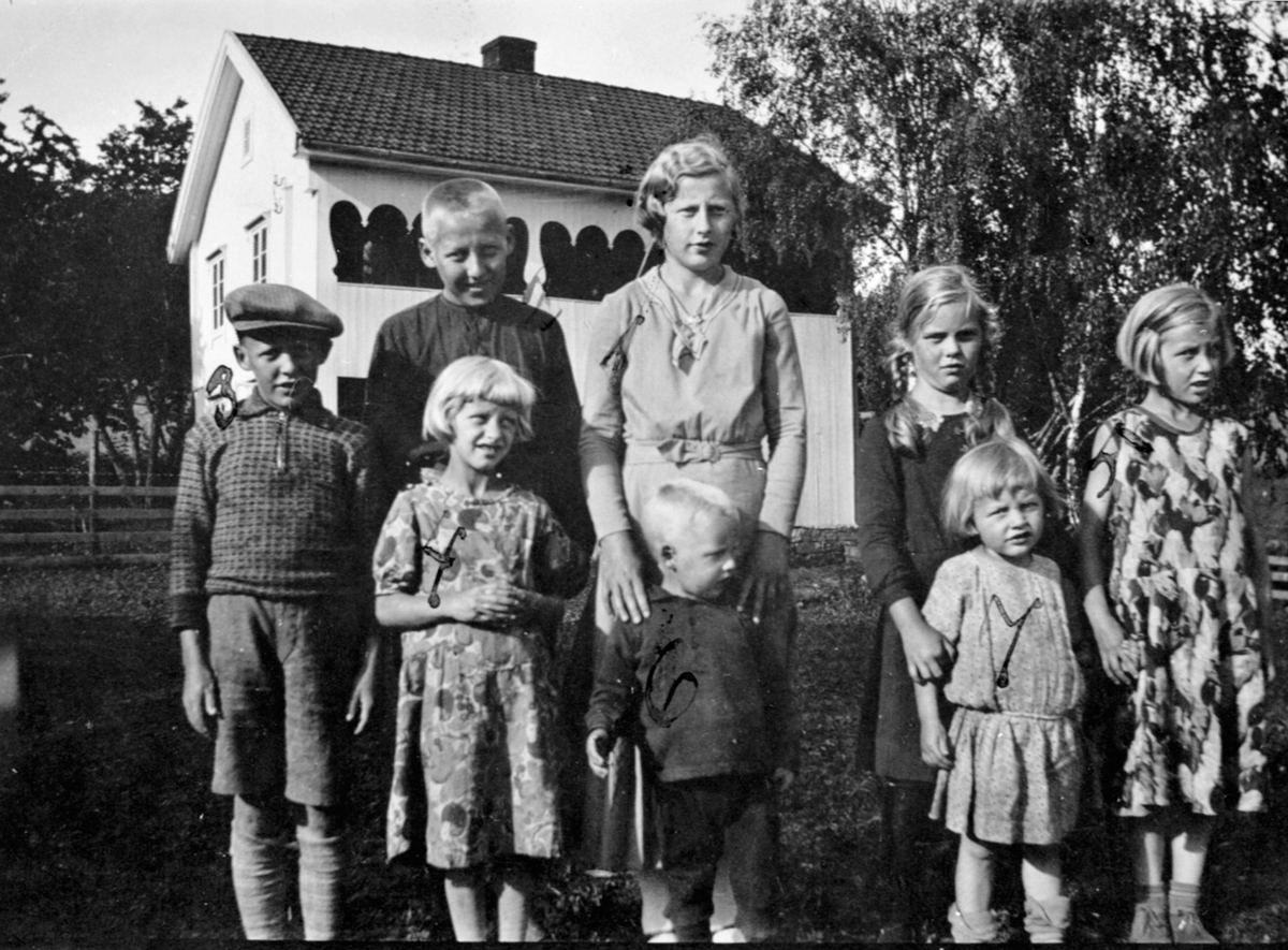 Gruppe barn foran den gamle hovedbygningen på Raknerud, Helgøya. Bak fra venstre er Eivind f.1921, Otto f.1919, Ragna f.1918 og Inga f.1924, Arnfrid Sandbæk f.1926. Foran fra venstre er Randi f.1925, Birger f.1929, Magnhild f.1929.