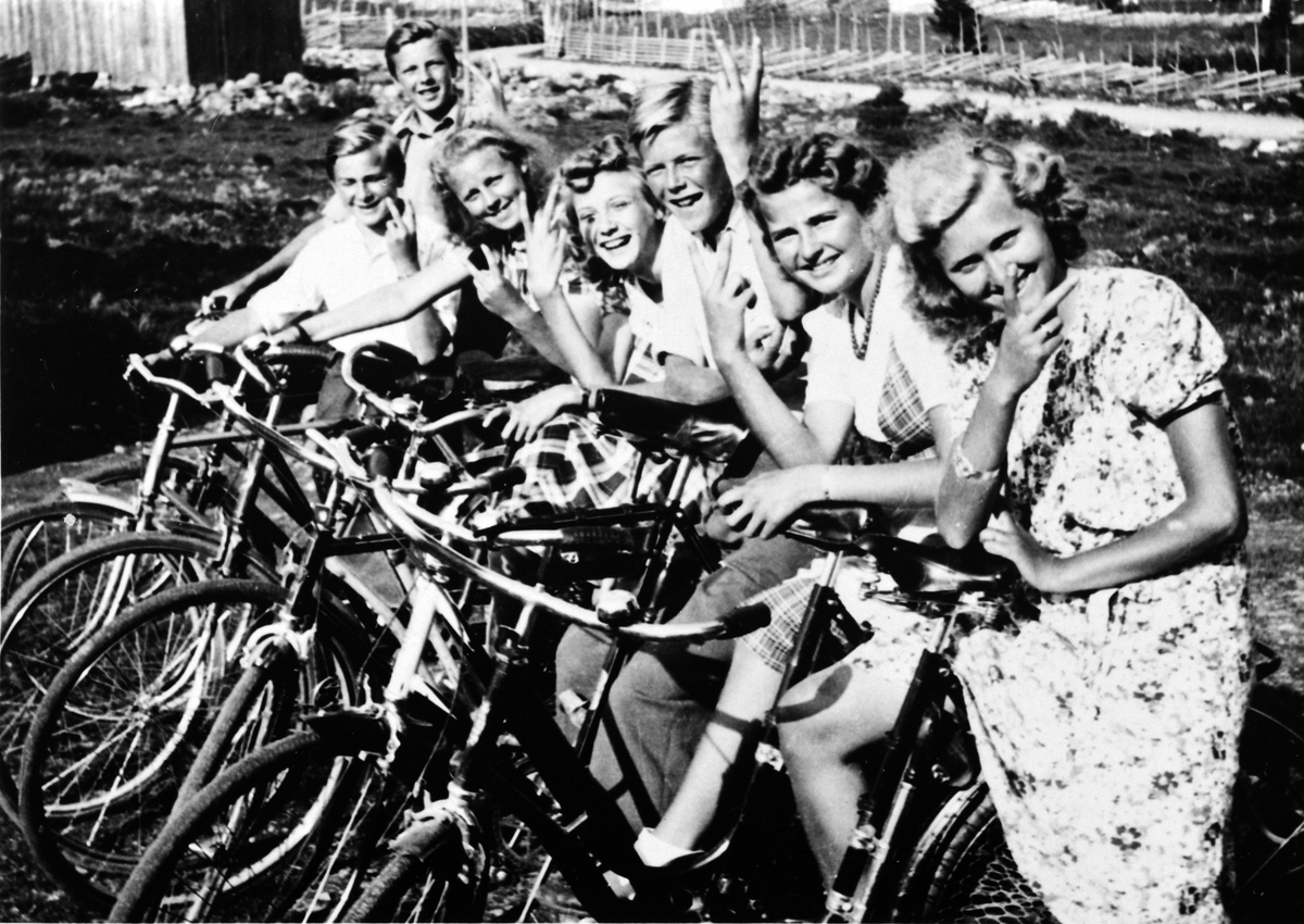 Ungdommer på sykkeltur under krigen, Sjusjøen, 1944. alle gjør v-tegn. Fra venstre er Leif Hornæss, Ole Solberg, ukjent, Solveig Hornæss, Arne Hornæss, Gerd Solberg, Agnes Solberg.