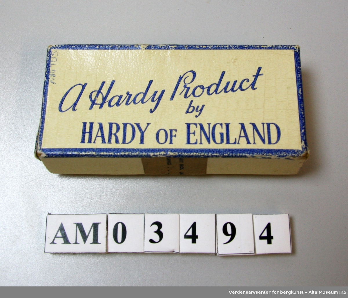 Pappeske med påtrykt "A Hardy Product by Hardy of England" på lokket. 

Inneholder en trippelkrok og en håndskrevet lapp med teksten: 

"Mustad 7228 EBB Superior Nr 1

Mustad 
Per Risberg
(061)74300
Nr 4 og 5"