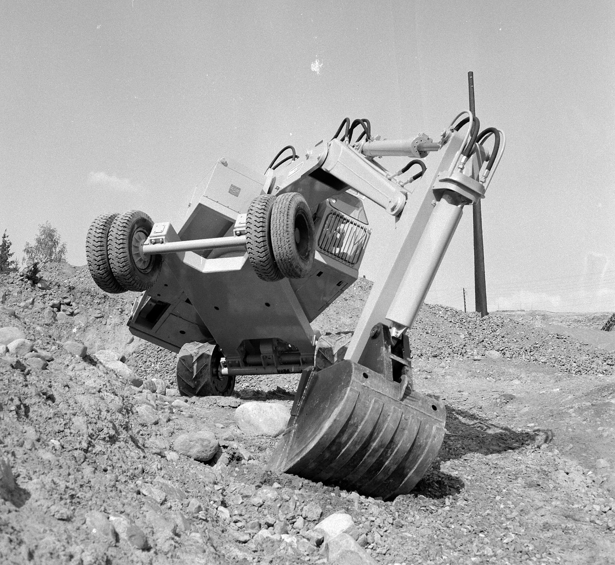 Munch gravemaskin. Maskinen hadde ikke drift på hjulene, men trakk seg fram med grabben. For lengre transport kunne maskinen hekte seg på planet til en lastebil, og kjøre på gummihjulene. Det andre hjulparet var av stål. Gravemaskinen Brøyt hadde samme oppsett. 