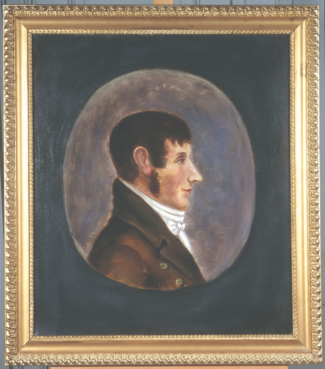 Portrett av Jørgen Aall. 
Mann med brunt hår, framoverkjemmet, og brunt kinnskjegg.  Brun kledning og hvit skjorte/halsbind.  2 synlige knapper.  Innskrevet i oval, lysere enn resten av bakgrunnnen