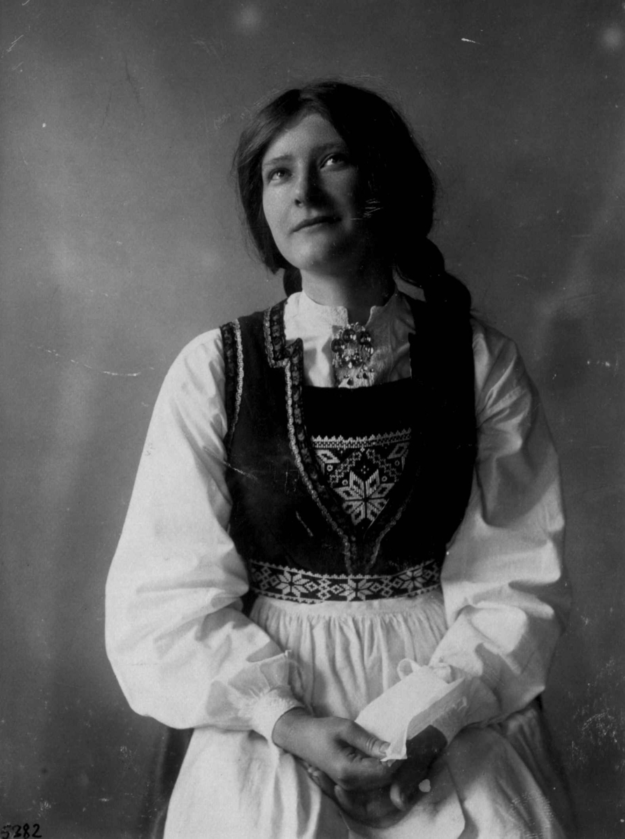 Kvinnedrakt fra Hardanger, Hordaland 1927. Kvinne med brev i hånden.