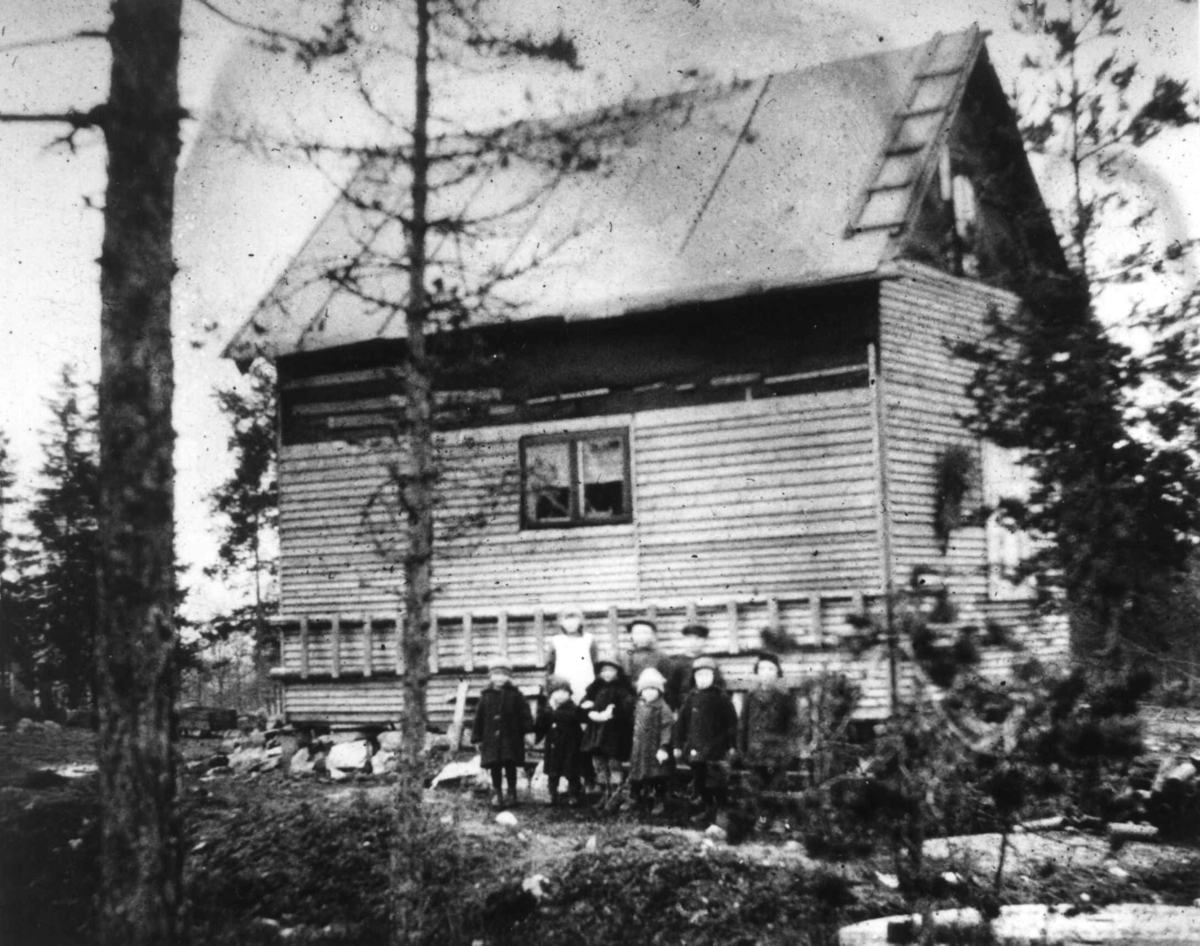 Bolighus, ant. Oslo. Barnegruppe poserer foran langvegg.
Fra boliginspektør Nanna Brochs boligundersøkelser i Oslo 1920-årene.