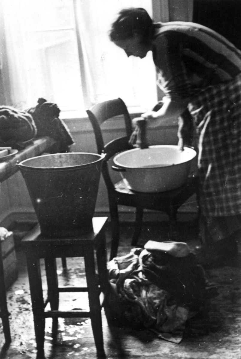Håndvask av tøy innendørs i balje og bøtte, Oslo. 
Fra boliginspektør Nanna Brochs boligundersøkelser i Oslo 1920-årene.