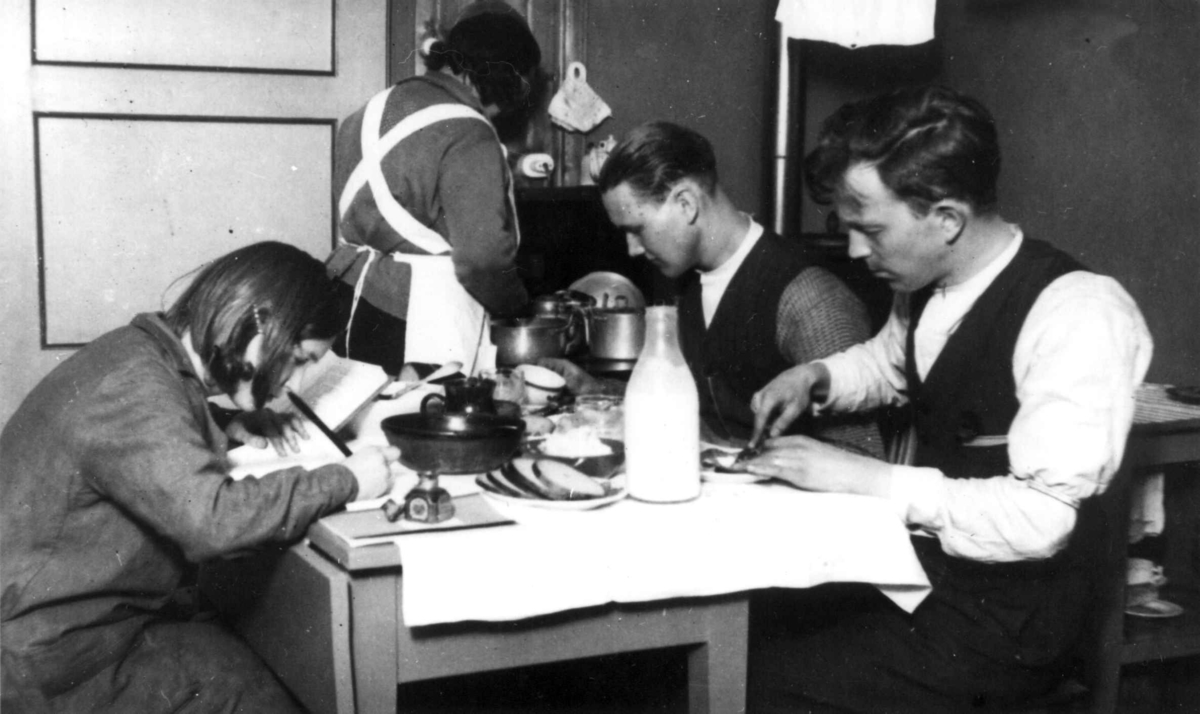 Interiør, kjøkken, Oslo. Matlaging, spising og lekselesing på liten plass.
Fra boliginspektør Nanna Brochs boligundersøkelser i Oslo 1920-årene.