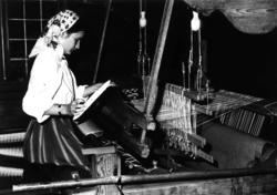 Trude Haaland ved vevstolen i Smestadstua, 1986. Hun vever f