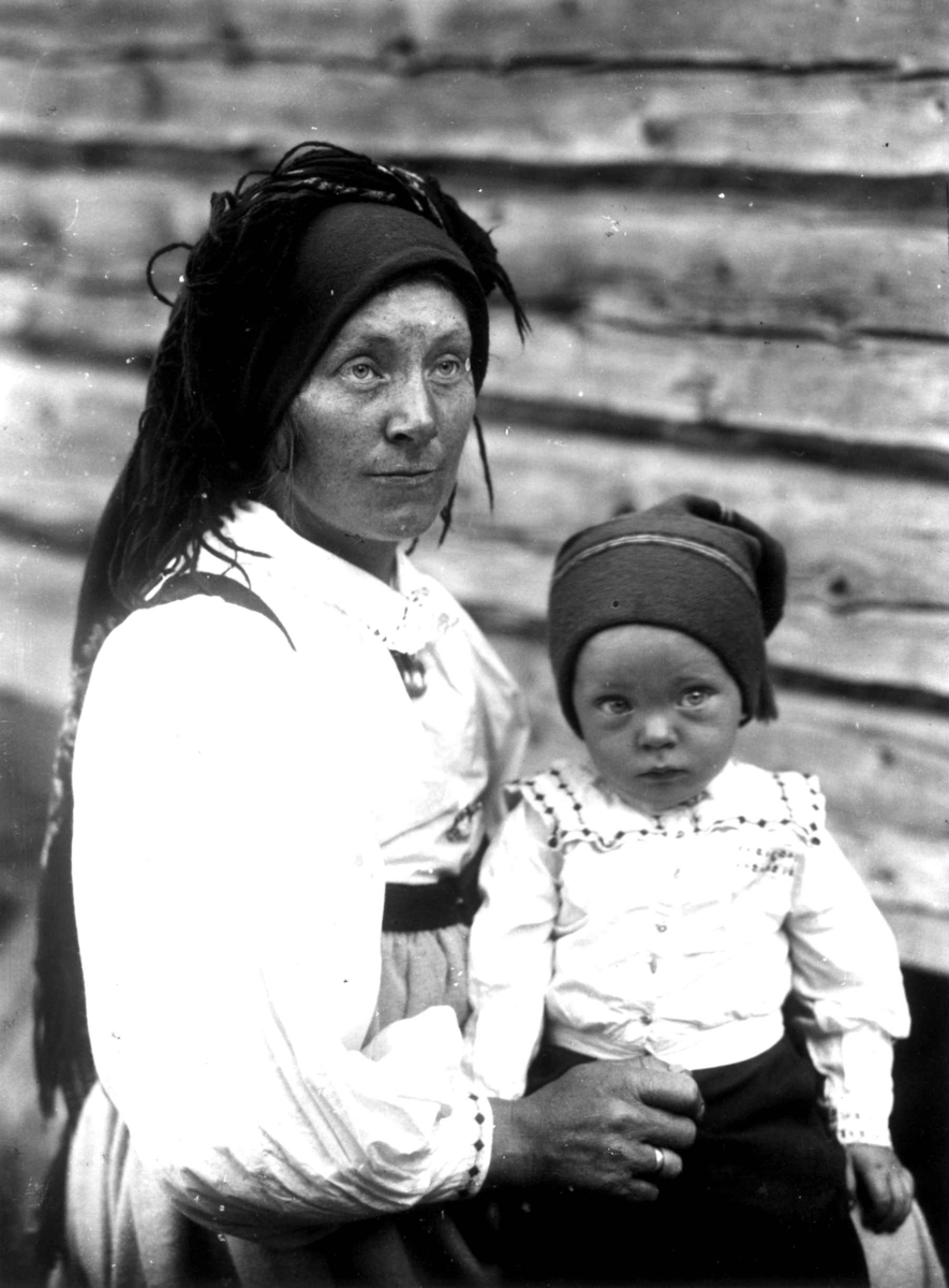 Kvinne- og barnedrakt, gruppeportrett, Valle, Setesdal, Aust-Agder, antatt 1924. Kvinne med sønn på fanget. Fra "De Schreinerske samlinger" (skal oppgis).