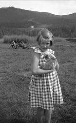 Guri Arentz med en katt på armen. I bakgrunnen ses
landskap