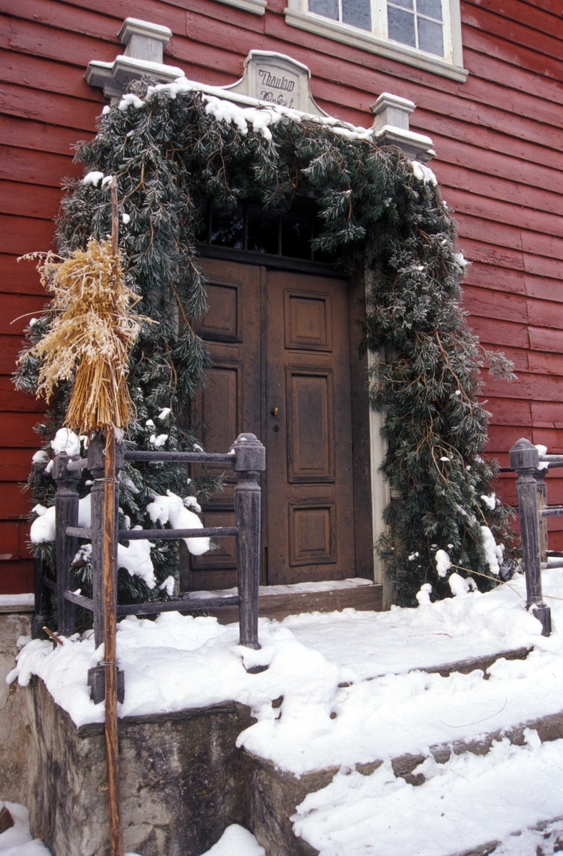 Prestegården, bygning nummer 191, fra Leikanger, nå på Norsk Folkemuseum, pyntet til jul. Inngangsdøren med fuglenek og granbar.
