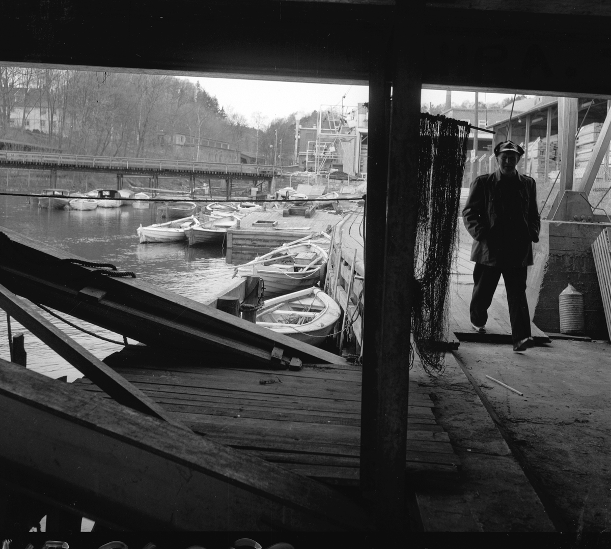 Trelastlager og båter på Farriselva i Hammerdalen, Riksvei 50. Fotografert 4. mai 1958.