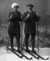 Gruppeportrett, mann og kvinne i skiutstyr i studio. Begge i