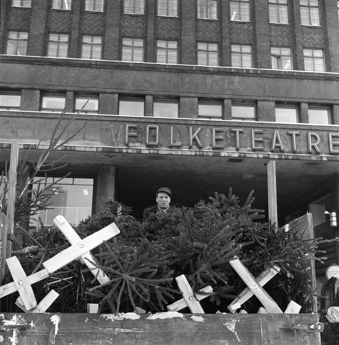 Juletresalg, Youngstorget, Folketeaterbygningen i bakgrunnen, lastebil og mann i forgrunnen, Oslo, 29.11.1956