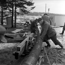 Trelleborg Gummi legger ut slange ved Sarpsborg, mars, 1959.