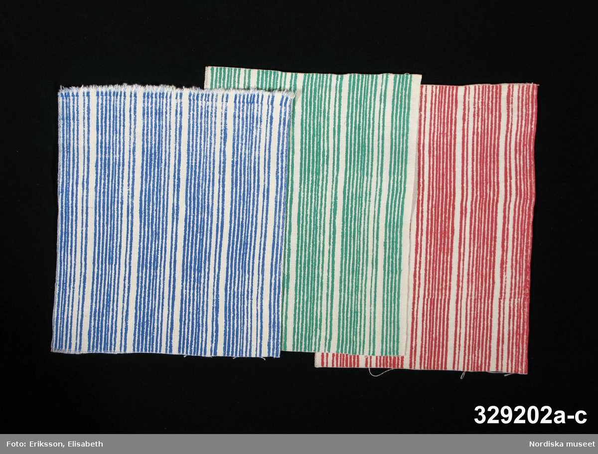 3 tygprover (a-c), på inredningstyg i samma randmönster. Mönstret heter Liljerand, komponerat 1946 av Astrid Sampe för NK:s Textilkammare.
Tryckt på linneliknande väv i cellull s.k. vistra, i en färg mot vit botten.
a) Mellanblå ränder.
b) Klargröna ränder.
c) Rosaröda ränder.
Alla tre proverna har en stadkant. På både det blå och det röda provet finns en färgskarv som visar att det är handtryckt med ram.
Tryckta i filmteknik som var en ny teknikvid 1930-talets mitt som NK:s Textilkammare var tidiga med. Föreståndaren Astrid Sampe beställde först hos Borås Väveri som tryckte och från 1944 samarbetade hon med Ljungbergs tygtryckeri i Floda i Västergötland. Många kända mönsterritare tecknade tryckmönster för NK.
Se vidare: Innez Svensson Tryckta tyger från 30-tal till 80-tal, Liber 1984 sid 20-23.
Proverna ingår i en större samling som alla tycks komma från NK:s Textilkammare och är från 1940-talets mitt. De har sparats av textilkonstnären Mai Wellner som 1944 kom som estnisk flykting till Stockholm där hon redan 1945 fick arbete hos Astrid Sampe på Textilkammaren. Hon stannade till 1946 och proverna borde därför vara från de åren.
/Berit Eldvik 2008-02-05