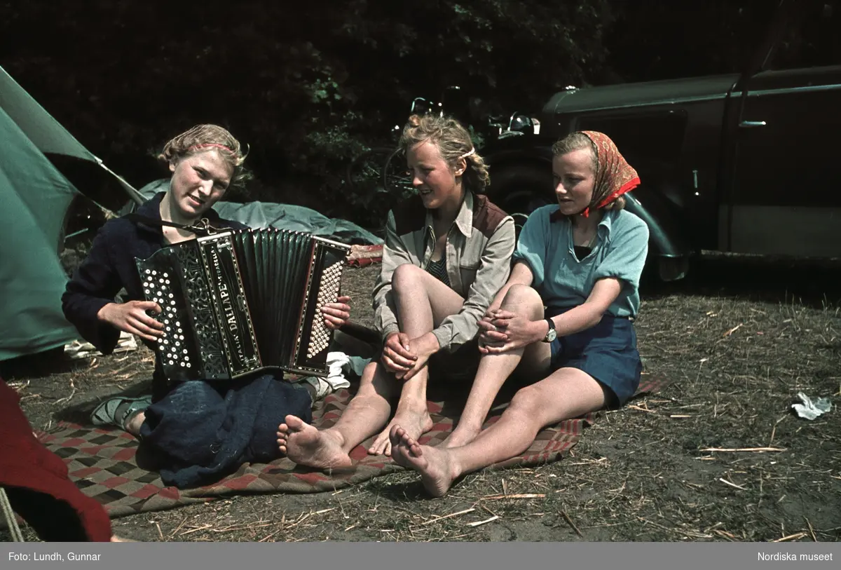 Fritid, semester. Unga kvinnor med dragspel sitter utanför tält i Mölle, Skåne.