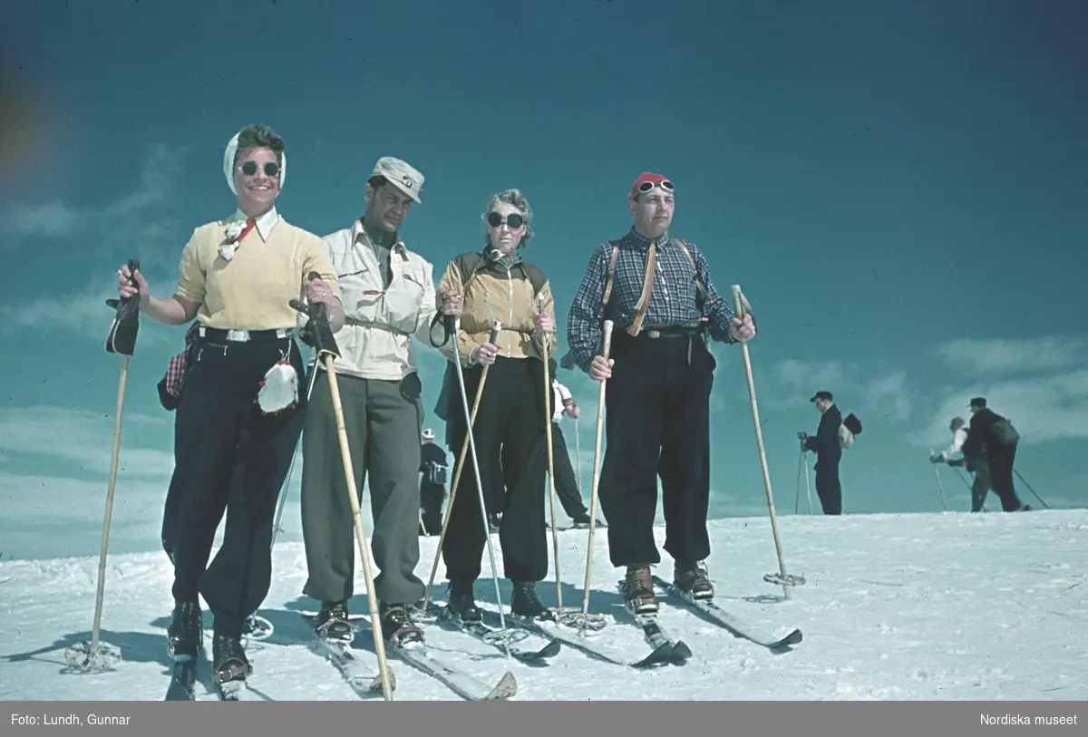 En grupp människor på skidor i solen på fjället.