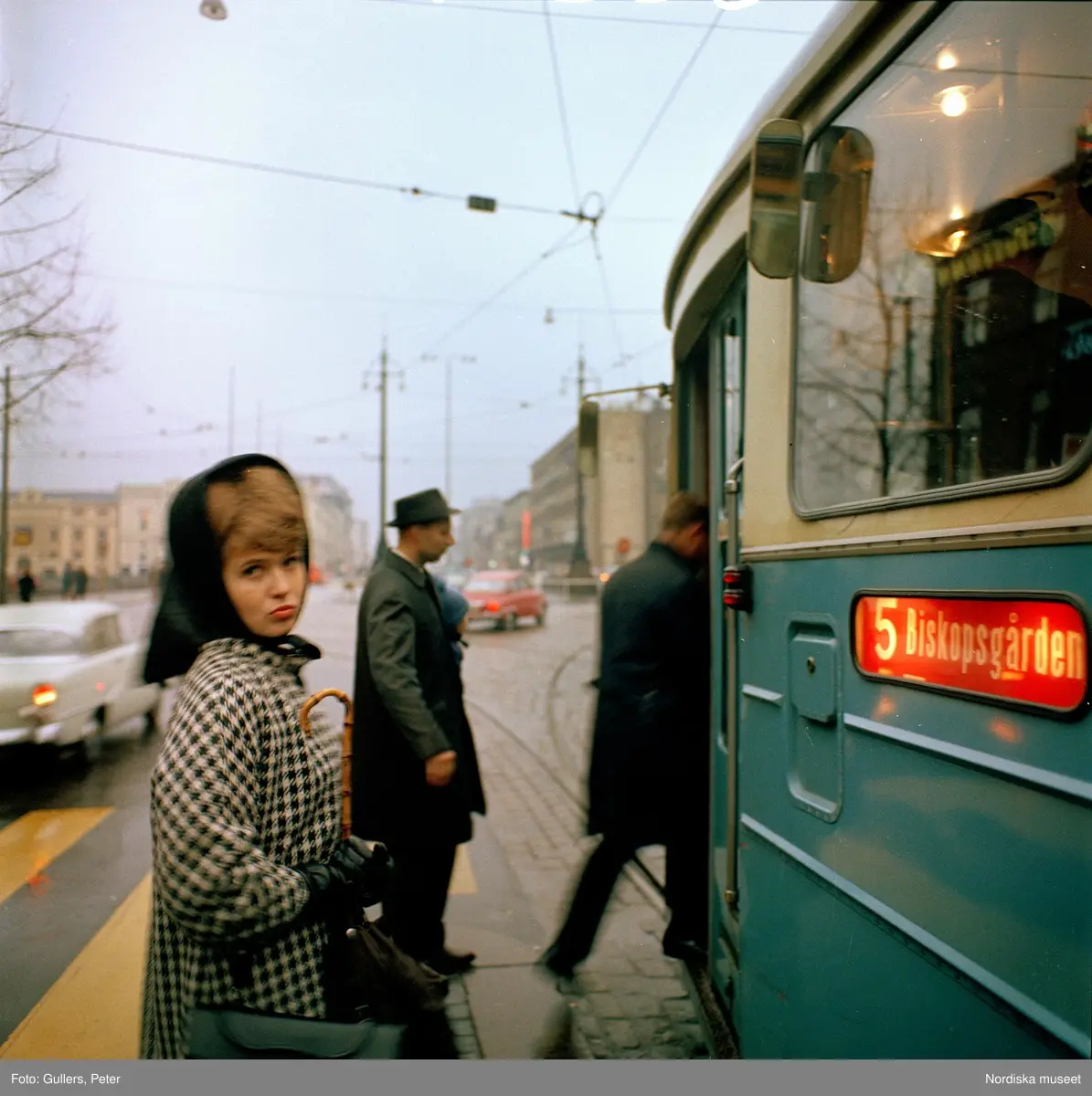 G&ouml;teborg. Kvinna invid sp&aring;rvagn. Tv&aring; m&auml;n stiger p&aring;.