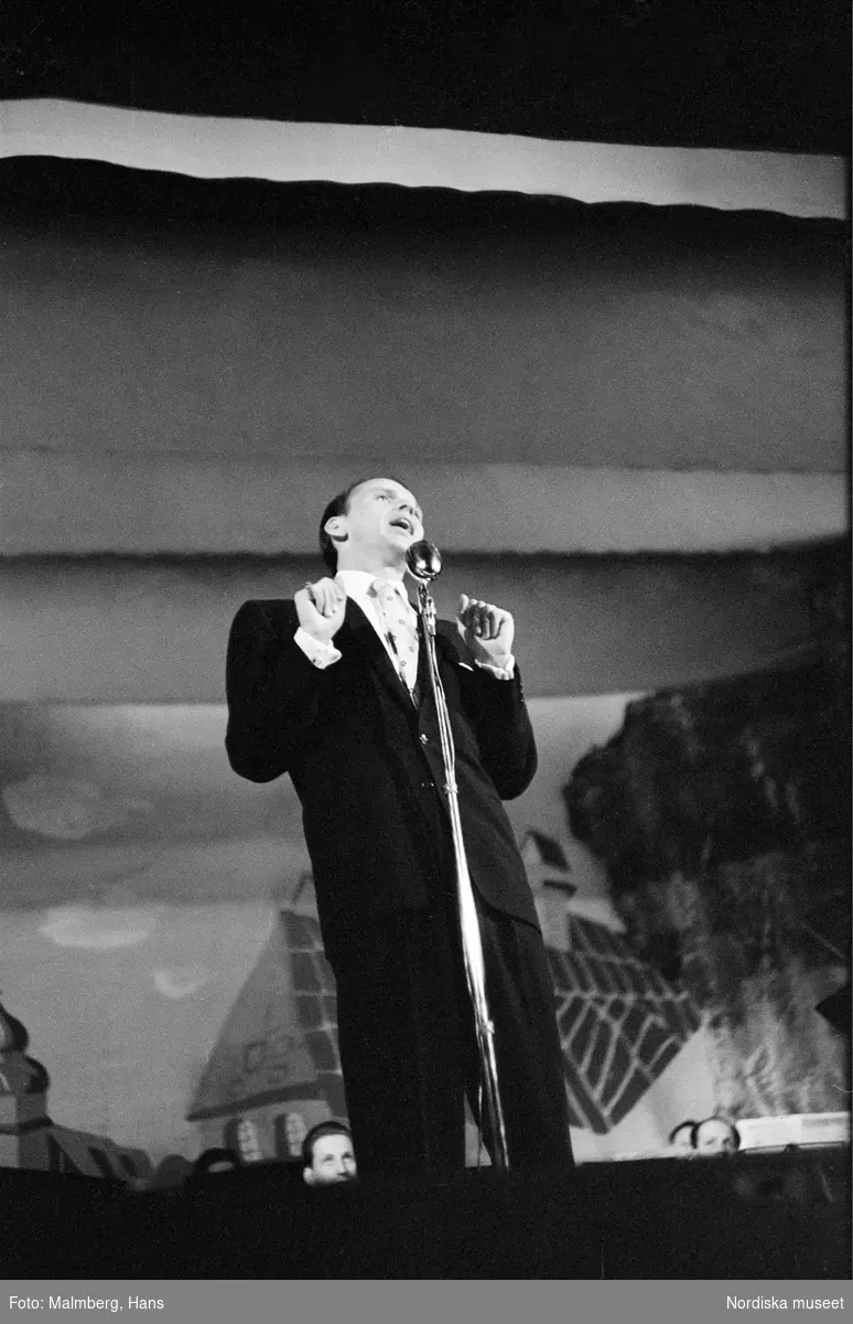 Frank Sinatra på turné i Sverige. Finspångs Folkets park. 
Sinatra sjunger i mikrofonen på scenen. 
