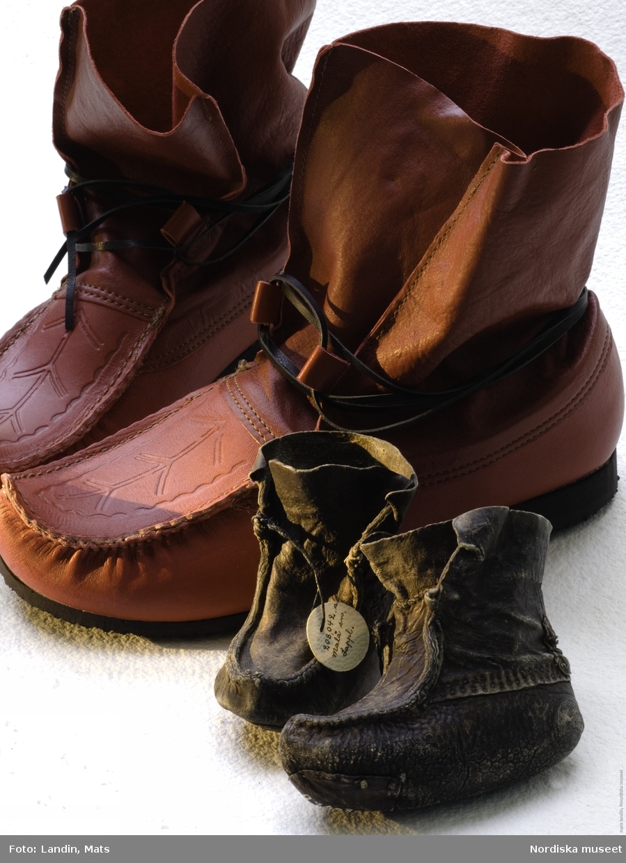 Näbbskor, nytillverkade och gamla.
Nydesignade röda skor från 2007 bredvid äldre småbarnsskor från Koppsele i Lappland. Den lätta renskinnsskon med sin karaktäristiska tåspets, näbb, har lång samisk tradition. Skon har länge varit uppskattad även utanför det samiska samhället. Ända sedan 1600-talet har näbbskorna utgjort en viktig samisk handelsvara. Barnens skor var kopior av de vuxnas dock med mjukare skinn, ofta sämskat renkalvskinn.